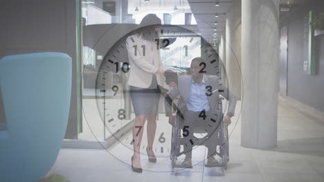 Animation-of-ticking-clock-against-diverse-businessman-on-wheelchair-discussing-with-woman-at-office