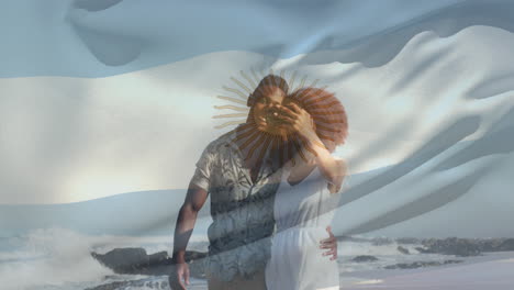 Zusammengesetztes-Video,-In-Dem-Die-Argentinische-Flagge-über-Einem-Afroamerikanischen-Paar-Schwenkt,-Das-Am-Strand-Ein-Selfie-Macht