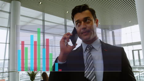 Animation-of-multicolored-bar-graphs-over-caucasian-man-talking-on-smartphone-in-office