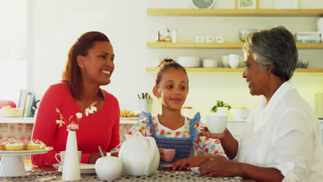 Happy-multi-generation-family-having-tea-in-dining-table-4k