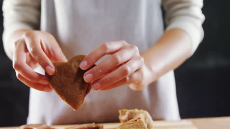 Woman-molding-gingerbread-dough-on-wooden-board-4k