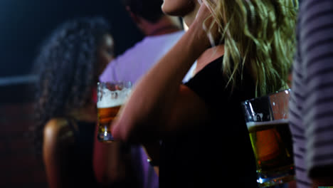 Woman-dancing-with-a-mug-of-beer-at-a-concert-4k