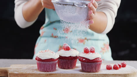 Woman-icing-sugar-powder-on-on-cupcakes-4k