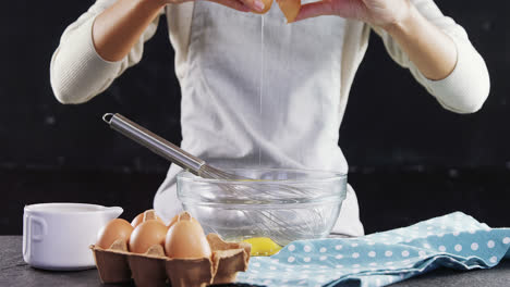 Woman-breaking-eggs-into-a-bowl-4k
