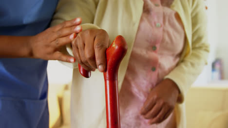 Female-doctor-helping-senior-woman-to-walk-with-walking-stick-4k