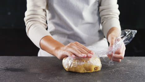 Woman-wrapping-dough-in-a-plastic-wrap-4k