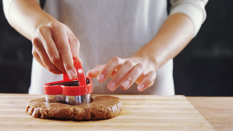 Woman-molding-gingerbread-dough-on-wooden-board-4k