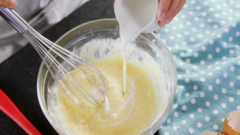 Woman-adding-milk-to-beaten-eggs-in-a-bowl-4k
