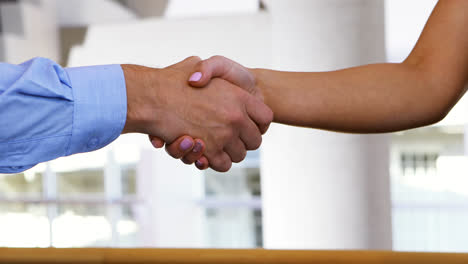 Executives-shaking-hands-in-conference-centre
