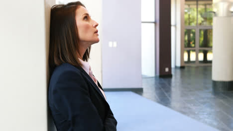 Upset-businesswoman-leaning-against-wall-4k