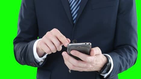Mittelteil-Eines-Kaukasischen-Mannes,-Der-Ein-Smartphone-Auf-Grünem-Hintergrund-Verwendet