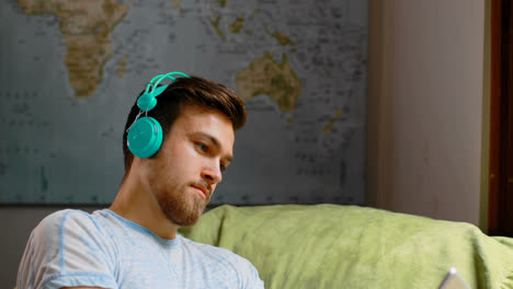Man-listening-music-on-digital-tablet-at-home-4k