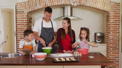 Kaukasische-Familie-Trägt-Schürzen-Und-Kocht-Gemeinsam-In-Der-Küche-Zu-Hause