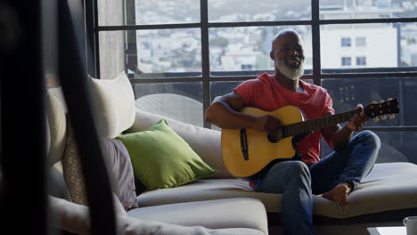 Senior-man-playing-guitar-at-home-4k