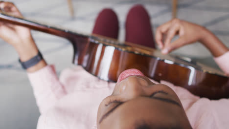 Draufsicht-Einer-Afroamerikanischen-Frau,-Die-Zu-Hause-Singt-Und-Gitarre-Spielt