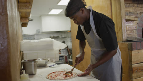 Mixed-race-man-making-a-pizza