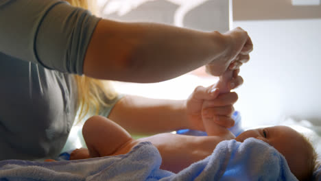 Mother-giving-hand-massage-to-her-baby-boy-at-home-4k