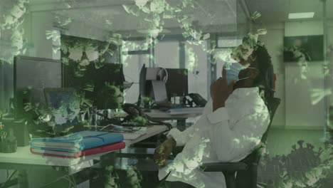 Animation-of-floating-covid-19-cells-with-man-in-office-wearing-face-masks