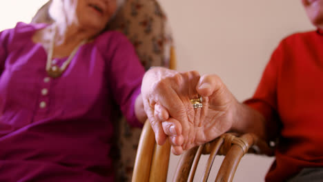 Mid-section-of-senior-couple-holding-hands-at-nursing-home-4k