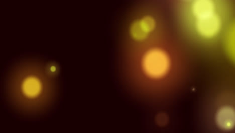 Animation-of-yellow-glowing-spots-of-light-moving-in-hypnotic-motion-on-black-background