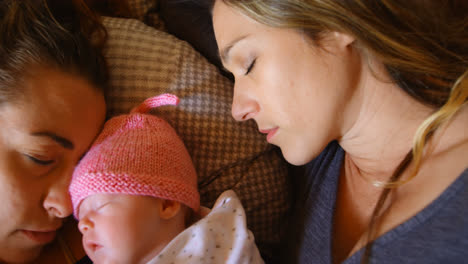 Lesbian-couple-sleeping-with-their-baby-boy-at-home-4k
