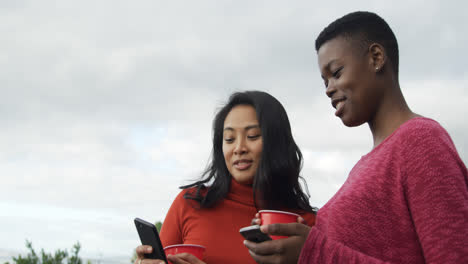 Junge-Frauen-Benutzen-Smartphones-Auf-Einem-Dach