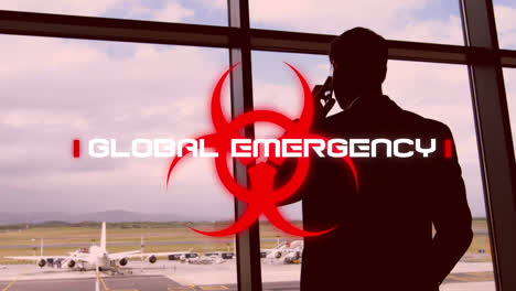 Warnschild-Mit-Globalem-Notfalltext-Gegen-Mann,-Der-Am-Flughafen-Mit-Dem-Smartphone-Spricht