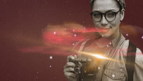Woman-holding-digital-camera-against-space-in-background