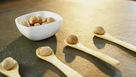 Nutmeg-arranged-in-wooden-spoon-and-bowl-4k