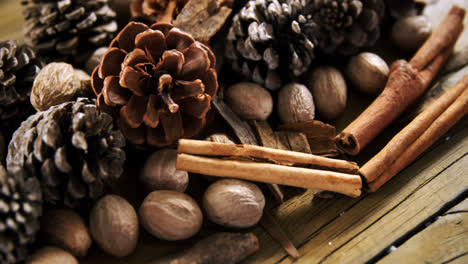 Pine-cones-and-cinnamon-sticks-on-wooden-table-4k