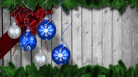 Video-composition-with-snow-over-Christmas-ornaments-on-wood