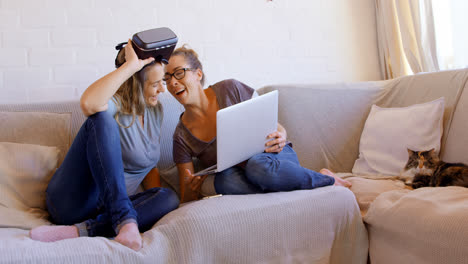 Lesbian-couple-using-laptop-in-living-room-4k