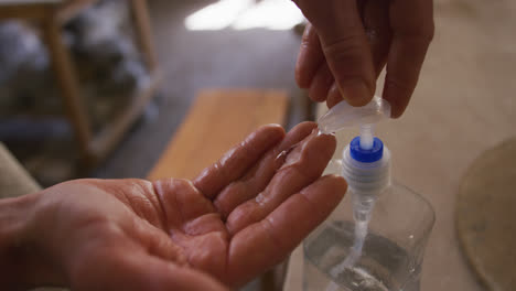 Nahaufnahme-Eines-Töpfers,-Der-Im-Töpferstudio-Ein-Händedesinfektionsmittel-Verwendet
