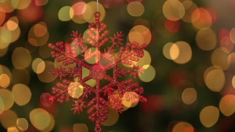 Digital-composition-of-glowing-golden-spots-of-light-against-christmas-snowflakes-decoration-hanging