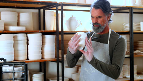 Male-potter-checking-ceramic-bowl-4k
