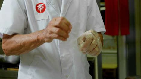 Male-chef-wearing-gloves-in-kitchen-4k
