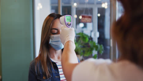 Woman-wearing-face-mask-getting-her-temperature-measured-at-hair-salon
