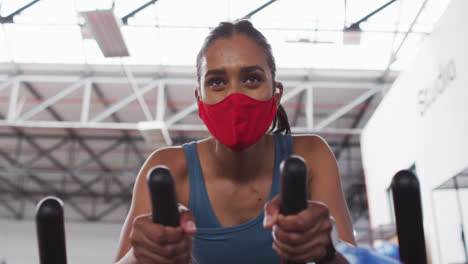 Frau-Mit-Gemischter-Rasse-Trägt-Gesichtsmaske-Beim-Training-Im-Fitnessstudio