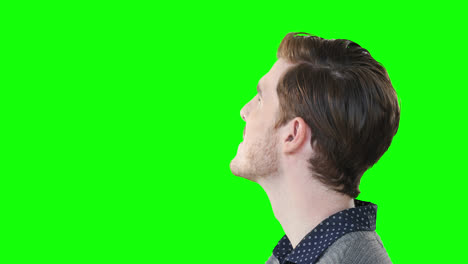 Caucasian-man-looking-up-on-green-background
