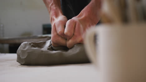 Close-up-view-of-male-potter-kneading-the-clay-at-pottery-studio