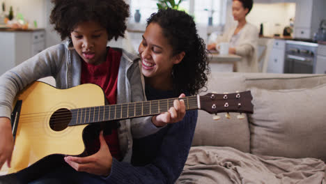 Mischlinge-Mutter-Und-Tochter-Sitzen-Auf-Der-Couch-Und-Spielen-Gitarre