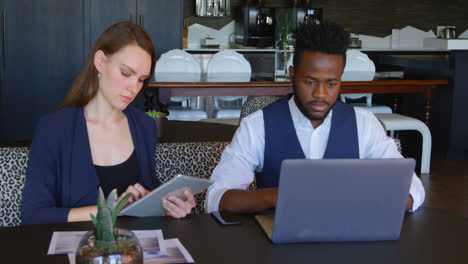 Front-view-of-Young-cool-mixed-race-business-team-working-on-multimedia-devices-in-a-modern-office-4