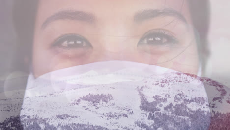 Digital-composition-of-portrait-of-woman-wearing-face-mask-against-winter-landscape