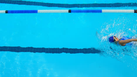Vista-De-ángulo-Alto-De-Una-Joven-Nadadora-Nadando-Dentro-De-La-Piscina-4k