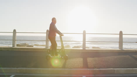 Senior-couple-using-electronic-scooters-alongside-beach