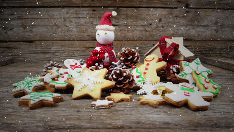 Video-composition-with-falling-snow-over-desk-with-ginger-cookies-and-santa-doll