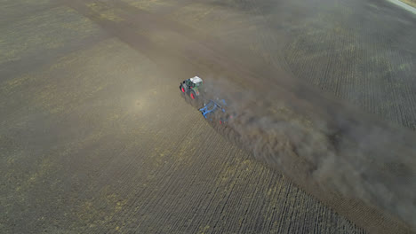 Aerial-view-of-tractor-moving-on-harvested-field-4k