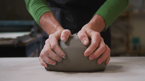 Close-up-view-of-male-potter-kneading-the-clay-at-pottery-studio
