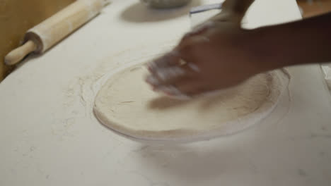 Mixed-race-man-making-a-pizza-dough