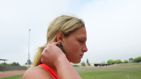 Side-view-of-Caucasian-female-athlete-getting-ready-for-throw-shot-put-throw-at-sports-venue-4k